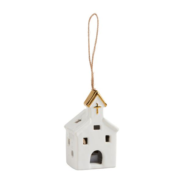 White ceramic house ornament with gold roof and cross on a white background